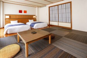 다다미 방의 낮은 테이블 옆에 놓인 트윈 침대