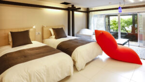 빨간 라운지 의자가 있는 객실의 침대 2개