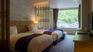 客室の大きな窓際にあるツインベッド