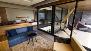 テラス近くにソファとツインベッドのある客室