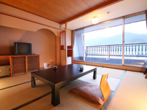 Camera in tatami con tavolo basso accanto a una grande finestra