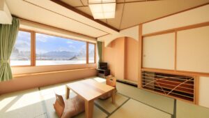 Camera in tatami con tavolino basso accanto a una grande finestra