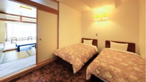 Letti singoli accanto a un'area salotto con tatami