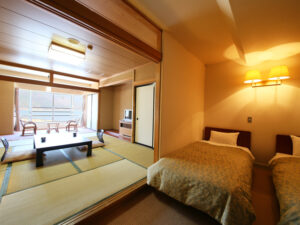 Letti singoli accanto a un’area salotto con tatami