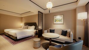 Dormitorio con dos camas, sofá y mesa redonda