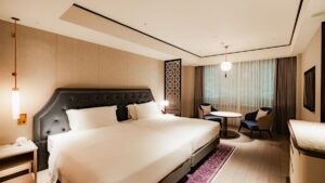 Dos camas en una habitación con mesa y sillas