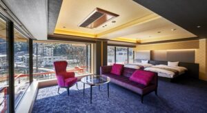 Chambre avec deux lits, un canapé et de grandes fenêtres