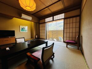 Chambre en tatami avec table basse, chaises et fenêtre