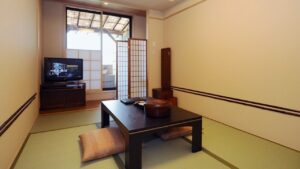 Tatami room with low table, cushions, and television