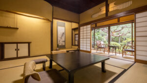 Tatamizimmer mit niedrigem Tisch und zum Garten gerichteten Stühlen