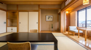Tatami-Zimmer mit niedrigem Tisch und Sitzplätzen am Fenster