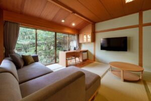 Tatami-Zimmer mit Sofa, Tisch und Schreibtisch am Fenster