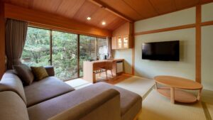 Tatamizimmer mit Sofa, Tisch, Schreibtisch und Gartenblick