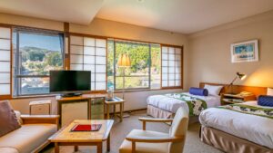 客室のツインベッドとシーティングエリア