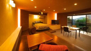 Habitación con cama, mesa, sillas y vista desde el balcón