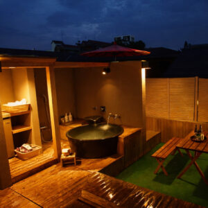 Baño privado al aire libre en una terraza de madera por la noche