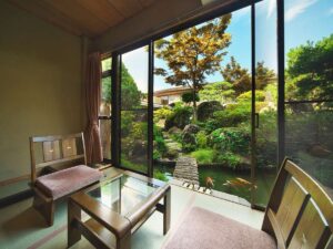 Zona de estar de la habitación con vista al jardín y al estanque de koi