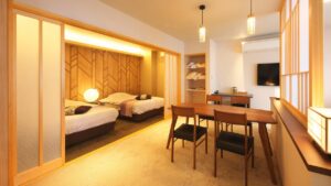 Camas individuales junto a una mesa y sillas en la habitación