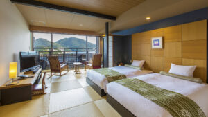 Twin beds in a tatami guest room with balcony view