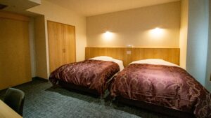 Dos camas individuales en una habitación sencilla