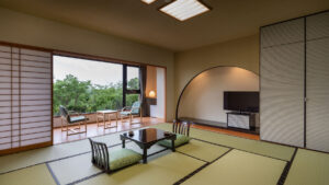 窓際に低いテーブルと椅子がある畳の部屋