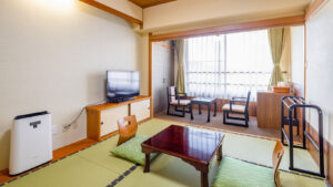 窓際に低いテーブルと椅子がある畳の客室