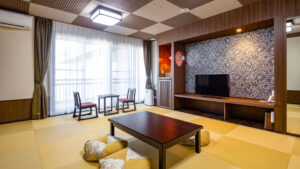 ローテーブル、座布団、椅子のある畳の客室