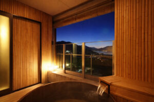 Baño privado junto a la ventana con vista nocturna a la montaña