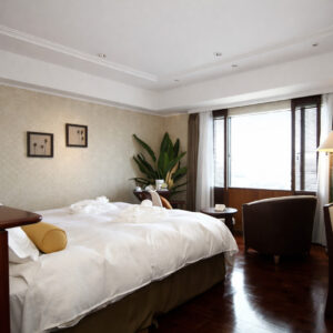Chambre avec grand lit, chaises et fenêtre
