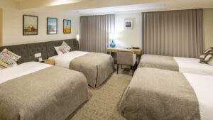 Chambre avec quatre lits simples et bureau