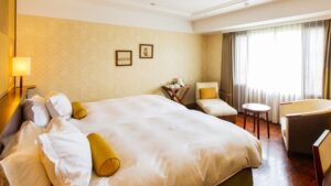 Grand lit près d’une chaise et d’une fenêtre dans la chambre