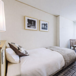 Lit simple dans une chambre avec chaise et décoration murale