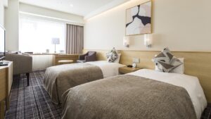 Lits jumeaux dans une chambre avec des fauteuils