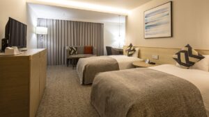 Chambre avec deux lits simples et des chaises