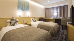 Lits jumeaux dans une chambre avec bureau et chaises