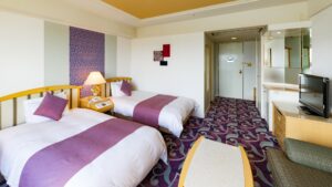 Lits jumeaux dans une chambre avec bureau et télévision