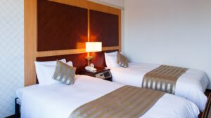 Deux lits jumeaux avec lampe de chevet dans la chambre