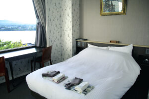 Doppelbett am Fenster mit gefalteten Yukata-Sets