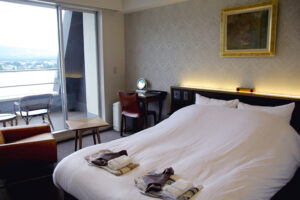 Doppelbett im Gästezimmer neben dem Balkonfenster