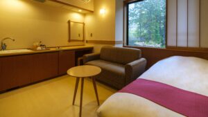 Bed beside sofa and table in guest room