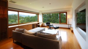 ソファとラウンジチェア、大きな窓のあるリビングスペース