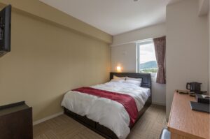 Doppelbett neben dem Fenster im Gästezimmer
