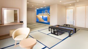 低いテーブル、椅子、遊び用の構造物がある畳の部屋