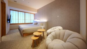 Schlafzimmer mit zwei Betten, Stühlen und Satztischen