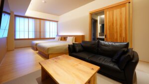 Schlafzimmer mit zwei Betten, Sofa und Holztisch