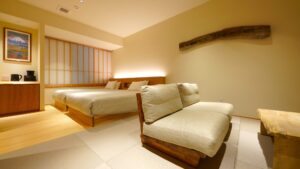 Gästezimmer mit zwei Einzelbetten und Sitzbereich mit Sofa