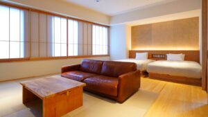 Gästezimmer mit zwei Betten, Sofa und niedrigem Tisch