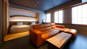 Ledersofa und Betten in einem Gästezimmer