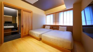 Zwei Einzelbetten in einem Gästezimmer mit Badezimmertür