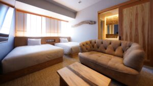 Zwei Betten mit Sofa und Tisch im Gästezimmer